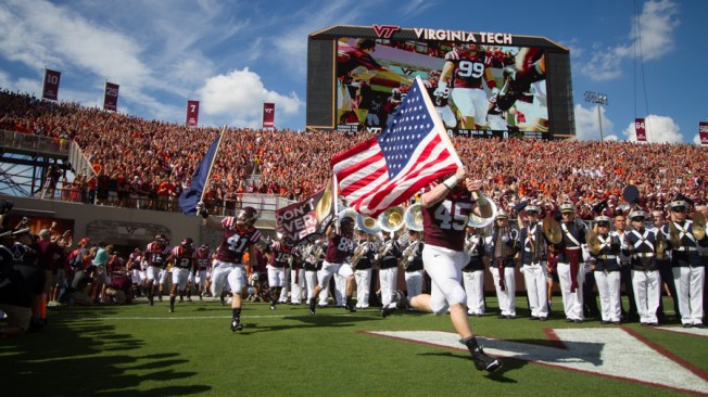Sam Rogers (45) carries the American flag to lead the Hokies into Lane Stadium for the first time this year.